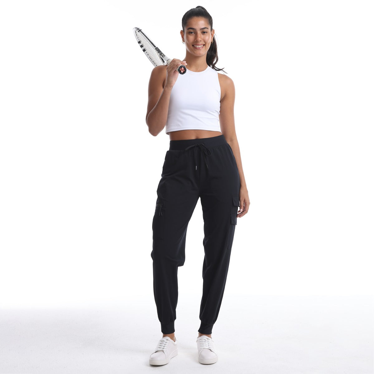 Model wearing the black 906 Cargo Jogger with a white top and sneakers, holding a tennis racket